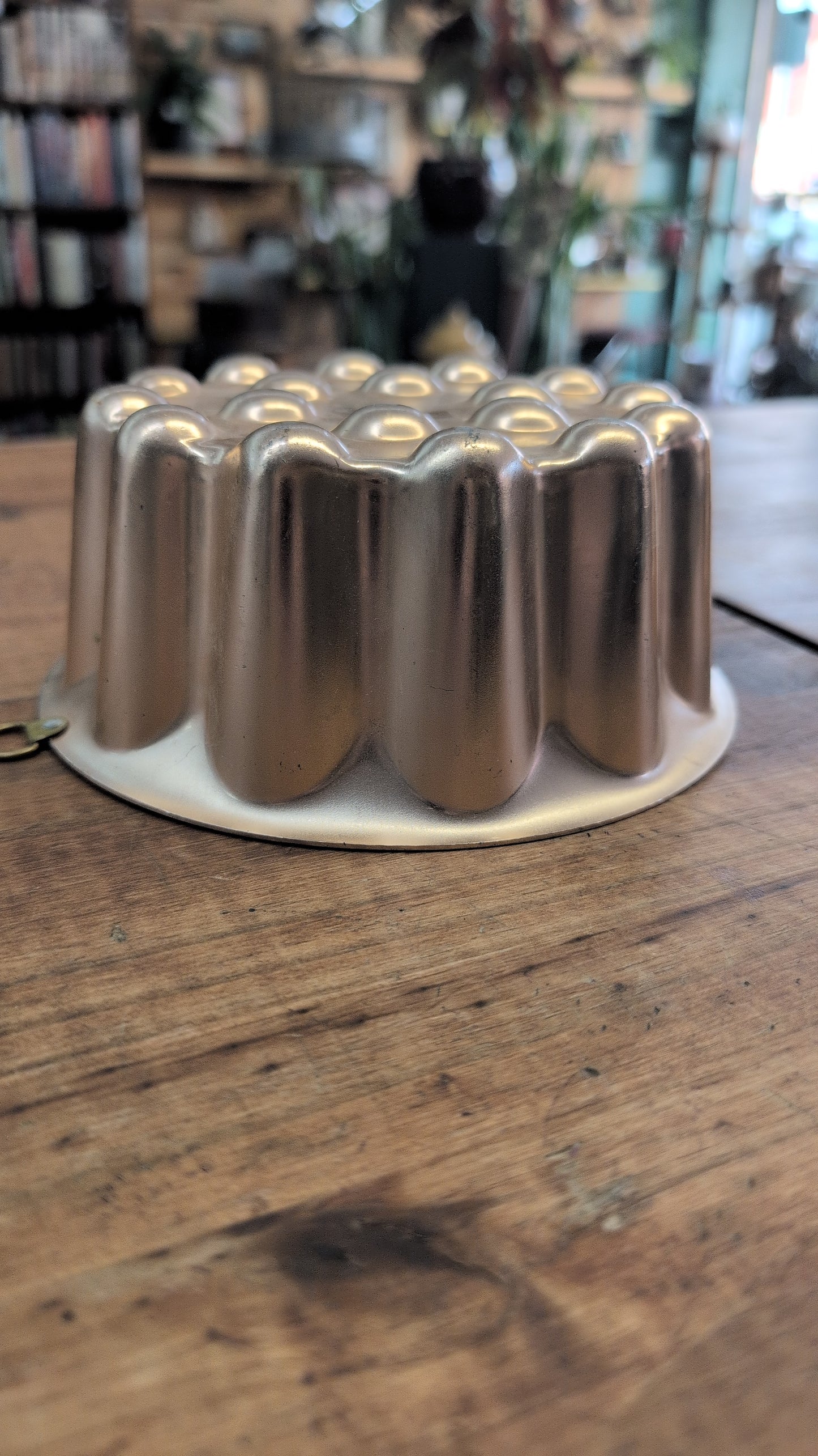 Vintage copper-toned aluminum gelatin mold with fluted sides and dimpled top.