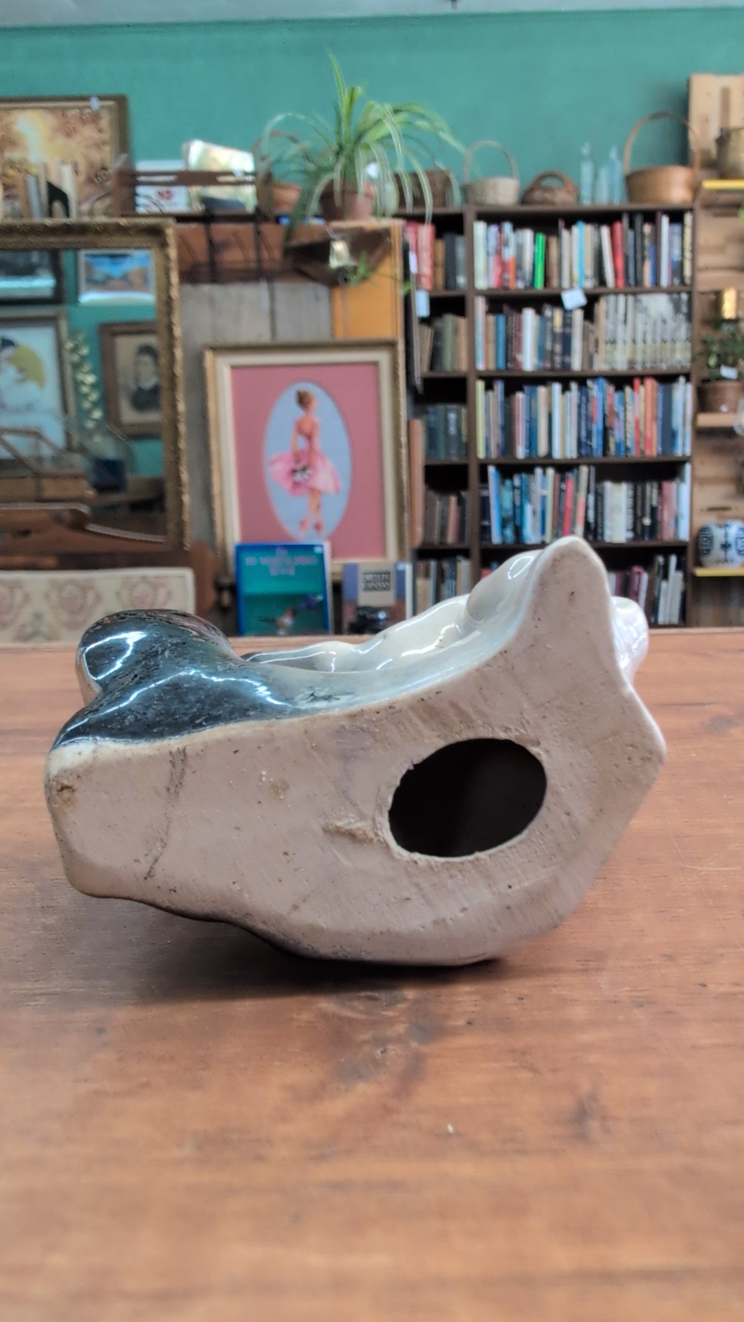Ceramic dog figurine perched on a black boot. 3 inch tall