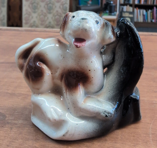 Ceramic dog figurine perched on a black boot. 3 inch tall