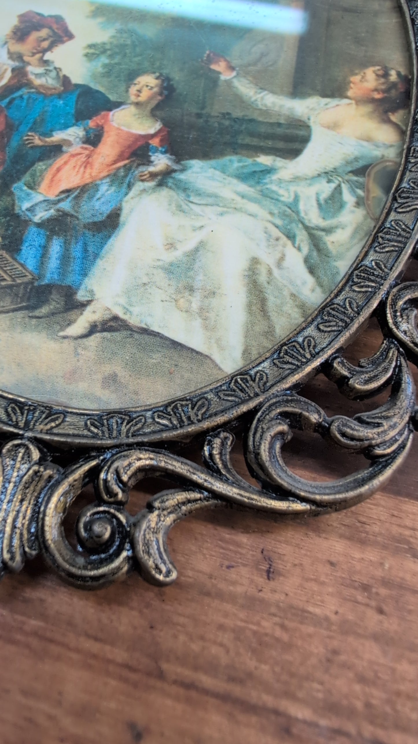 Rococo-style pastoral scene print in an ornate metal frame.