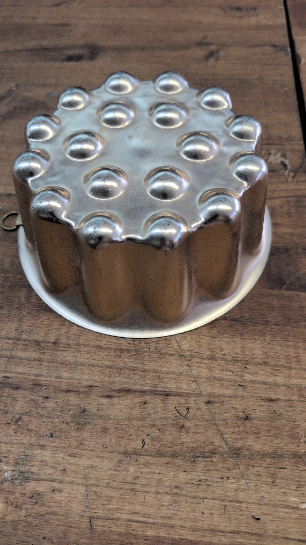 Vintage copper-toned aluminum gelatin mold with fluted sides and dimpled top.