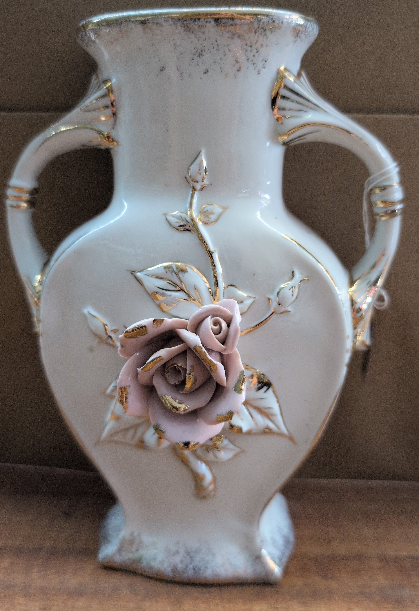 Japanese porcelain vase with raised rose and gold trim.